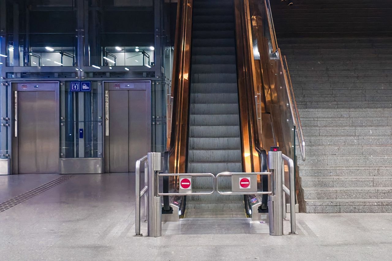 A modern indoor escalator and elevators in a public space, showcasing urban architecture.